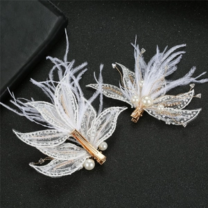 Détail de pince à cheveux en plumes blanches et dentelle avec perles et strass brillants