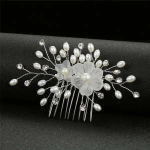 Détail du peigne à cheveux pour mariée avec perles, cristaux et fleurs en résine blanche
