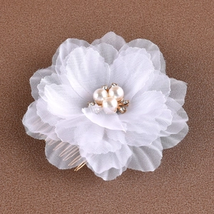 Détail du peigne mariée avec fleurs en tulle, perles artificielles et cristaux sur métal doré