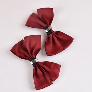 Detail view of the silver metal clips on the back of wine red satin bow shoe decorations