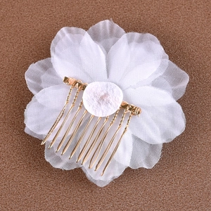Détail du peigne à cheveux de mariée avec fleurs blanches et dents en métal doré