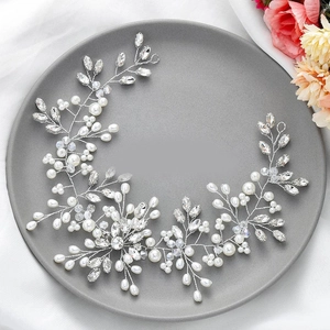Detail of silver bridal hair vine with white pearls and sparkling crystals on a ceramic plate