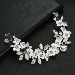 Elegant bridal hair vine with white ceramic flowers, silver leaves and pearls on black base