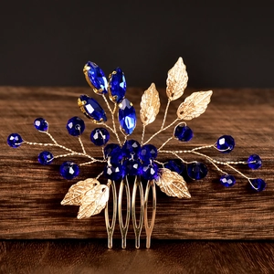 Detail of emerald green crystals and golden metal leaves on a bridal hair comb