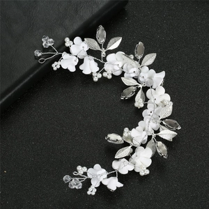 Detail of bridal headband with white clay flowers, silver leaves and faux pearls