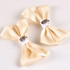 Detail of white satin bow shoe clips with silver metal crocodile clips and felt padding