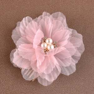 Détail d'un peigne à cheveux avec fleurs en organza rose, perles et strass brillants
