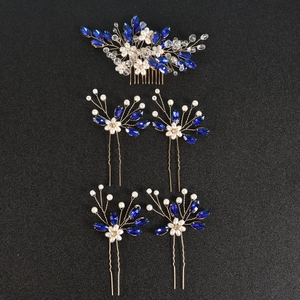 Détails de cristaux bleus et perles blanches sur des peignes de mariée dorés