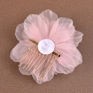 Détail du peigne de mariée à fleurs en maille rose avec des broches dorées et rembourrage