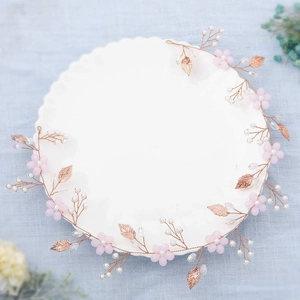 Détail du bandeau rose doré avec fleurs roses, perles blanches et perles de cristal sur plateau