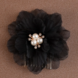 Vue détaillée du peigne à cheveux avec fleurs noires en tissu et perles élégantes