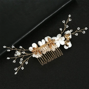 Detail of handmade white fabric flowers and mini pearls on gold bridal hair comb