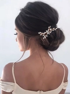 Gros plan sur l'épingle à cheveux de mariée en or rose avec strass dans un chignon