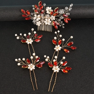 Détail macro du peigne à cheveux de mariée avec cristaux rouges et perles sur fil doré