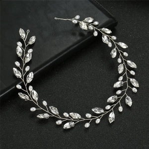 Elegant bridal headband with crystals and pearls on a textured black background