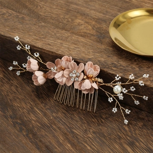 Pink floral bridal hair comb with pearls and rhinestones on a vintage wood background