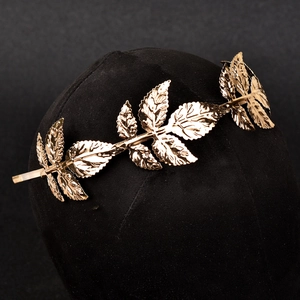 Detailansicht des goldenen Legierungs-Stirnbands mit Blattmuster und metallischem Glanz
