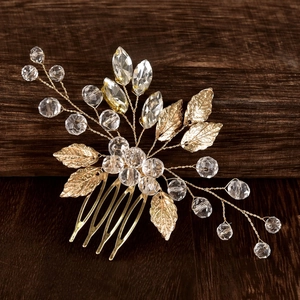 Detailed macro view of golden metal leaf and emerald crystal on the bridal hair comb