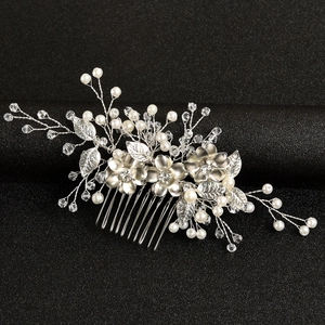Macro detail of bridal hair comb featuring handmade pearls and crystal flower petals