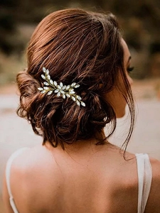 Détail d'une épingle à cheveux de mariée avec strass en verre marquise sur chignon élégant