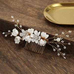 Detailed macro view of white fabric flowers with rhinestones and pearls on a gold bridal comb
