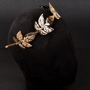 Eleganter Haarreif mit goldenen Blättern und Metalltextur auf schwarzem Modellkopf