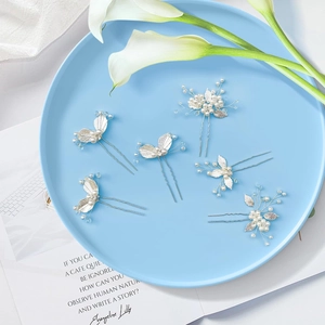 Dettaglio delle forcine in lega d'argento con foglie e perle bianche in set