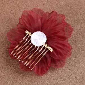 Vue détaillée des pétales de fleurs en tissu rouge foncé et du peigne en métal doré