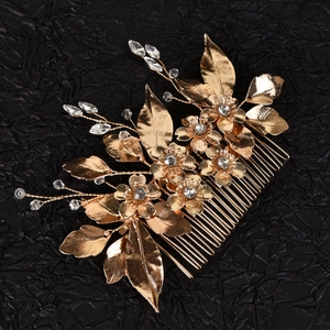 Detailed close-up of golden bridal hair comb with alloy flowers and sparkling crystals