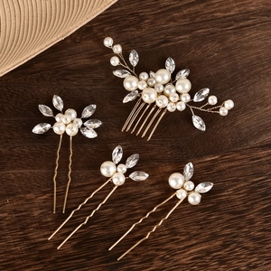 Peigne et épingles de mariée dorés avec perles et cristaux sur fond de bois sombre