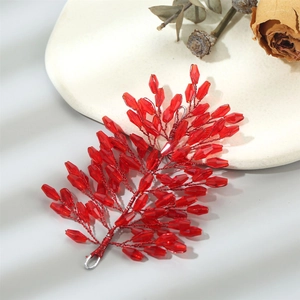 Detail of leaf-shaped hair accessory with handcrafted red crystal beads and wire