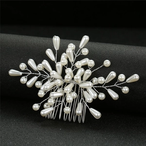 Détail de peigne à cheveux de mariée fait main avec perles et fil argenté sur fond noir