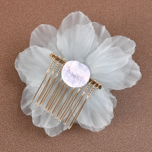 Détail du peigne à cheveux fleur en tulle bleu clair avec dents en métal doré et dos en feutre