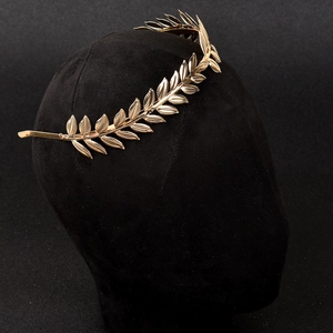Detailaufnahme des goldenen Lorbeerkranz-Haarreifens mit Metallblättern auf schwarzer Büste