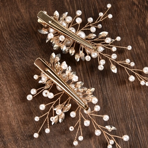 Dettaglio dei fermagli per capelli da sposa fatti a mano con perle e foglie di cristallo