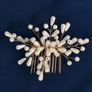 Vue détaillée d'un peigne à cheveux de mariée avec perles et fils dorés sur velours