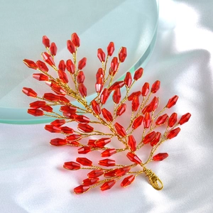 Detail of red crystal beads and gold wire vine on white silk for wedding hair accessory