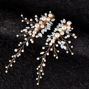 Dettaglio di fermagli per capelli da sposa con perle bianche e cristalli marquise blu