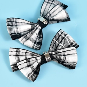 Detail showing a pair of black and white checkered bow shoe clips with silver metal buckles