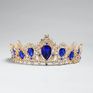 Close-up of golden crown with blue teardrop crystals and sparkling rhinestones for brides