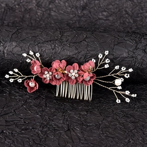 Detailed close-up of velvet flowers and pearl branches on a gold bridal hair comb