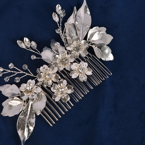 Close-up of bridal hair comb with silver alloy flowers and sparkling crystal beads