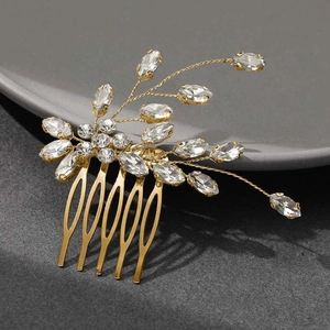 Dettaglio ravvicinato del pettine da sposa dorato con cristalli su piatto in ceramica