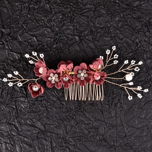Detailed close-up of handmade bridal hair comb with dark red flowers and white pearls