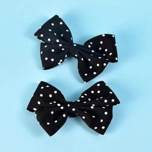 Detail of two black and white polka dot bow shoe clips for bridal wedding accessories