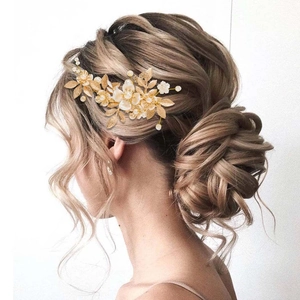 Bijou de tête de mariée avec feuilles dorées et perles sur une coiffure sophistiquée