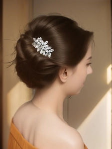 Peigne à cheveux de mariée argenté avec cristaux et feuilles porté sur un modèle