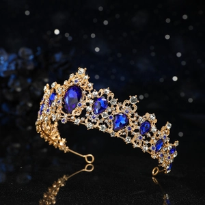 Macro detail of golden bridal tiara featuring blue teardrop gems and white rhinestones
