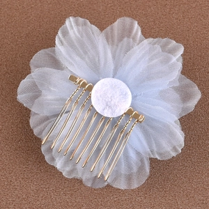 Détail du peigne à cheveux de mariée avec grandes fleurs en maille blanche et dents dorées