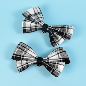 Set of two black and white plaid bow shoe clips with metal attachment on blue backdrop